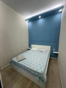 a small bed in a room with a blue wall at Paronyan 20 guest hause in Yerevan