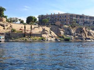 a building on the shore of a body of water at Katadool Boat in Aswan