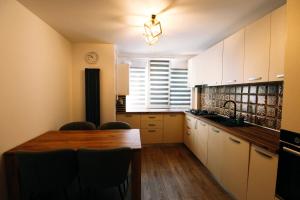 een keuken met een houten tafel en een aanrechtblad bij DaVinci Apartment with Self Check-In in Târgu-Mureş +2 foto's