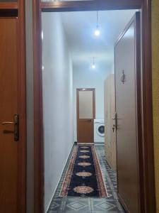 einen Flur mit einer Tür, die zu einer Waschküche führt in der Unterkunft Jimmy Apartment in Tirane