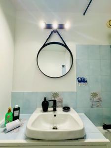 ein Badezimmer mit Waschbecken und Spiegel an der Wand in der Unterkunft The Urban Stop - Apartment Near Paris & Disney in Noisy-le-Grand