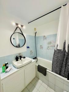 ein Badezimmer mit Waschbecken und Badewanne in der Unterkunft The Urban Stop - Apartment Near Paris & Disney in Noisy-le-Grand
