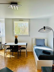 ein Schlafzimmer mit einem Bett und einem Tisch und einem Fenster in der Unterkunft The Urban Stop - Apartment Near Paris & Disney in Noisy-le-Grand