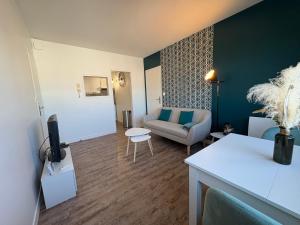 una sala de estar con un sofá y una silla en Le Cocon de Port-Louis, en Port-Louis