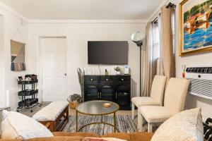 ein Wohnzimmer mit Sofa und Fernseher in der Unterkunft Echo Park Spacious Two-Bedroom Apartment with Private Yard and Parking in Los Angeles