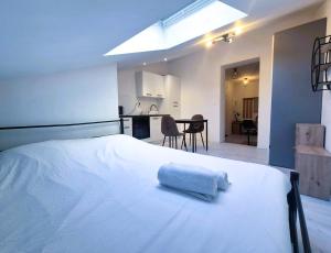 ランスにあるAstana - Concon confortable & Harmonieuxのタオルが敷かれた白いベッドのある寝室