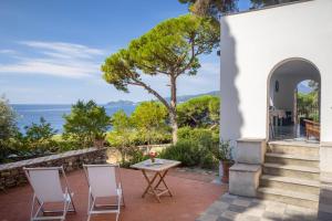 a patio with a table and chairs and the ocean at Giardino in villa Margherita in Zoagli
