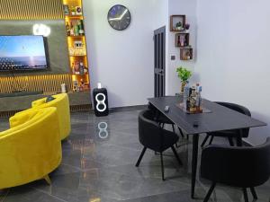 une salle à manger avec une table et des chaises jaunes dans l'établissement Villa YVES, à Baguida