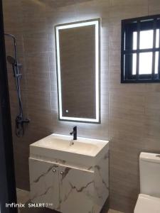 une salle de bain avec un lavabo blanc et un miroir dans l'établissement Villa YVES, à Baguida