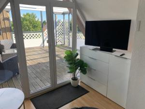 a living room with a flat screen tv on a dresser at Über den Dächern der Stadt in Bremervörde