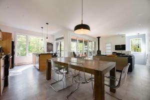 a kitchen and living room with a wooden table and chairs at Cottage 18 place de la Réserve in Eastman