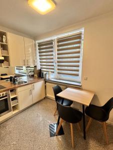 een keuken met een tafel en stoelen en een raam bij Modern City Apartment 1 in München