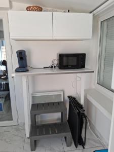 a kitchen with a counter with a microwave and a stove at bienvenu au SPA ELENA in Aulnoye-Aymeries