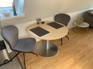 a table and four chairs in a room at Über den Dächern der Stadt in Bremervörde