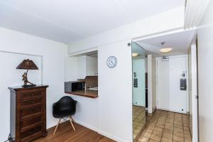 une chambre avec une chaise et un réveil sur un mur dans l'établissement Ilikai Tower 1113 - Fully furnished condo with FREE wifi, à Honolulu