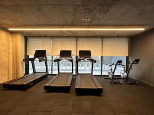 a gym with several treadmills and exercise bikes at HOM I Lujoso Depto 2D2B, Ñuñoa con Estacionamiento in Santiago +28 photos