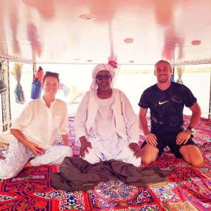 three men sitting on the floor of a bus at Katadool Boat in Aswan