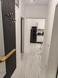 a kitchen with white walls and a marble floor at Terra Ștrand Residence Ștei in Ştei +2 photos