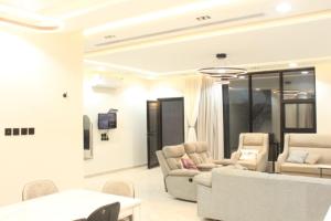 Una sala de estar con sofás y sillas y un televisor. en فيلا راقية وسط المدينة, en Az Zulfi