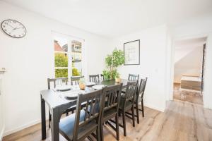 a dining room with a table and chairs and a clock at BackHome - MAISIONETTE - 120qm - Fantastische Schlosslage - SmartTV - Waschmaschine - Netflix - 24h Checkin- Apartment 4 in Ludwigsburg