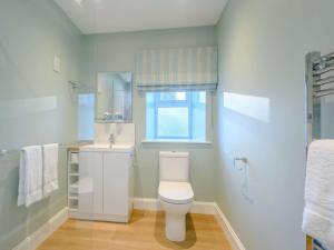a bathroom with a toilet and a sink and a window at 1 Bed in Lockerbie 86068 in Lockerbie +8 photos
