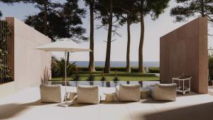 a patio with chairs and an umbrella and a pool at HADRIE Luxury 9 Villas by the Sea in Malinska