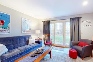 Una sala de estar con un sofá azul y una silla. en Salt Mountain Condo, en Warren