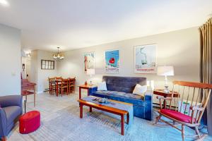 Una sala de estar con un sofá azul y una mesa. en Salt Mountain Condo, en Warren