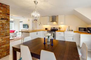 a kitchen with a wooden table and white cabinets at Seatoller Unit C in Ludlow