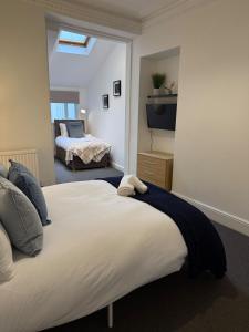 Un dormitorio con una cama grande con un televisor en la pared. en Spacious 6-Bed Home for Work Crews & Groups, en Sketty