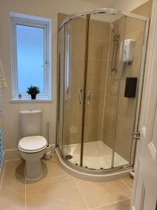 baño con ducha, aseo y ventana en Spacious 6-Bed Home for Work Crews & Groups, en Sketty 29 fotos más