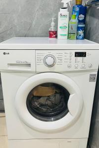 a white washing machine with cleaning products on top of it at Каратал 6Б in Taldykorgan
