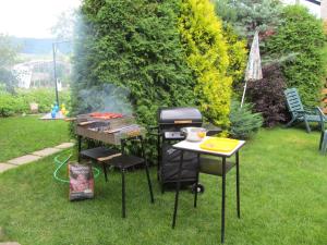 a barbecue grill and a table with a grill at Apartments Ľubka in Zuberec