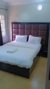 a large bed with a large headboard in a bedroom at Royale Signature in Lagos
