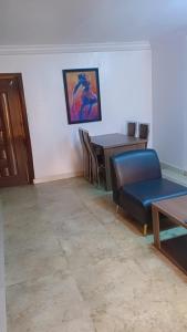 a living room with a table and a blue chair at Royale Signature in Lagos