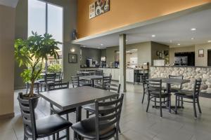 a restaurant with tables and chairs and a counter at SureStay Plus Hotel by Best Western Lethbridge in Lethbridge