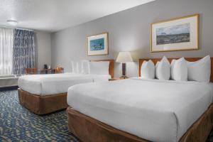 a hotel room with two beds and a window at SureStay Plus Hotel by Best Western Lethbridge in Lethbridge +33 photos