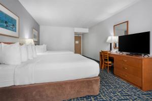 a hotel room with a large bed and a flat screen tv at SureStay Plus Hotel by Best Western Lethbridge in Lethbridge