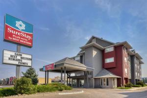 a building with a sign in front of it at SureStay Plus Hotel by Best Western Lethbridge in Lethbridge
