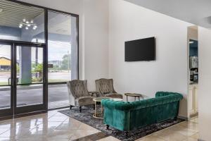 a living room with a couch and two chairs at SureStay Studio by Best Western Victoria in Victoria