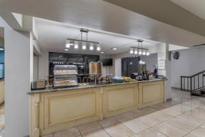 a restaurant with a counter with food on it at SureStay Studio by Best Western Victoria in Victoria