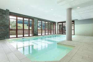 a large swimming pool in a building with windows at Résidence Odalys Le Panoramic in Flaine