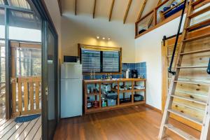 a kitchen with a refrigerator and a staircase at Black Orchid Cabaña at Inn The Trees -Gold Standard Certified in Seine Bight Village