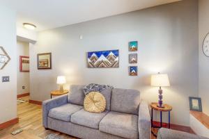 a living room with a couch and a clock on the wall at Los Pinos #D10 in Breckenridge