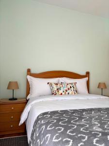 a bedroom with a large bed with two lamps at Chimpanzee Forest House in Karpenision +21 photos