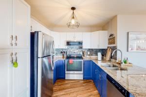 a kitchen with blue cabinets and a stainless steel refrigerator at Hilltop Hideaway - Legacy 401AB in Big White