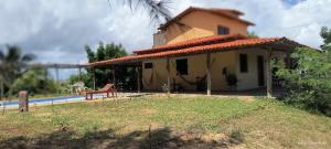 a small house with a bench in front of it at Casa Nativa Coqueiro II in Luis Correia