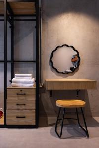 a table and a stool in a room with a mirror at C Living 3 - Al Malqa in Riyadh