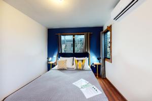 a bedroom with a bed with blue walls and a window at Toucan Cabaña at Inn The Trees -Gold Standard Certified in Seine Bight Village