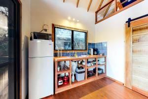 a kitchen with a white refrigerator and a window at Toucan Cabaña at Inn The Trees -Gold Standard Certified in Seine Bight Village
